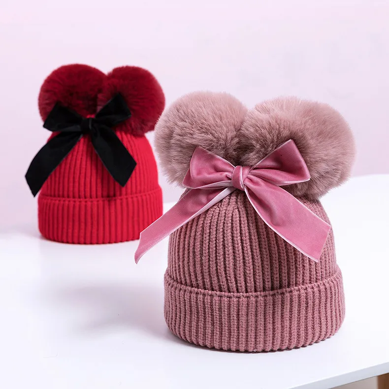 Knitted pompom hat with velvet bow