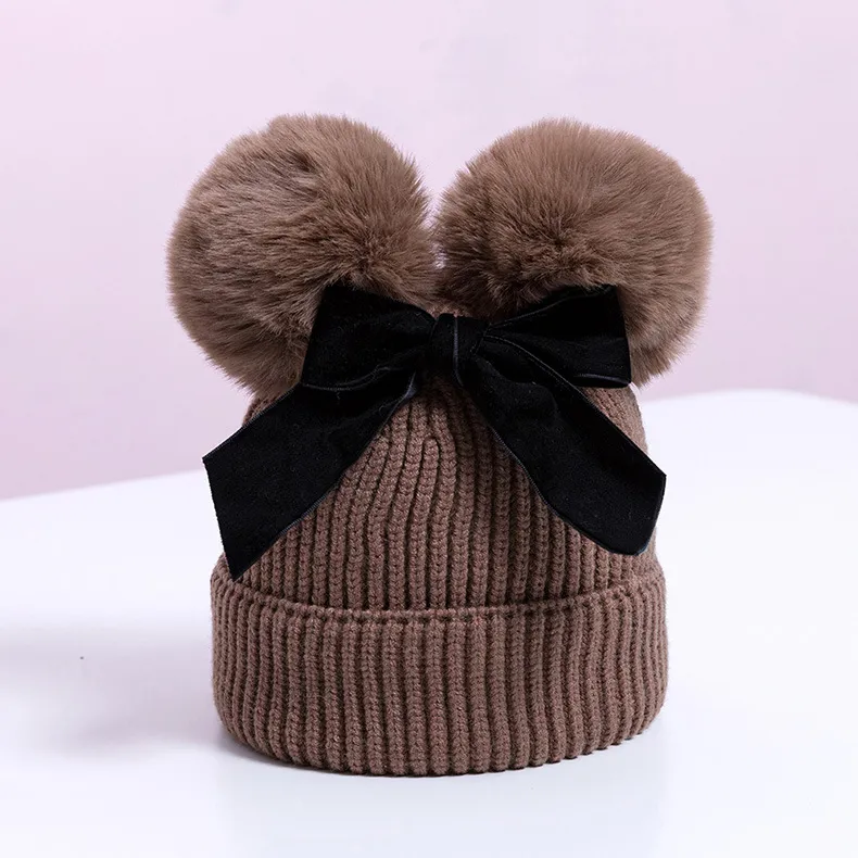 Knitted pompom hat with velvet bow