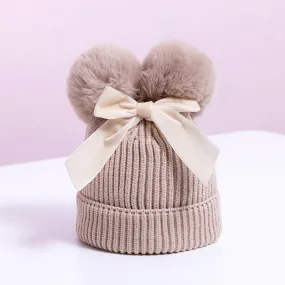 Knitted pompom hat with velvet bow