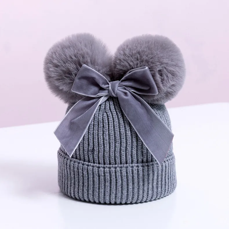 Knitted pompom hat with velvet bow