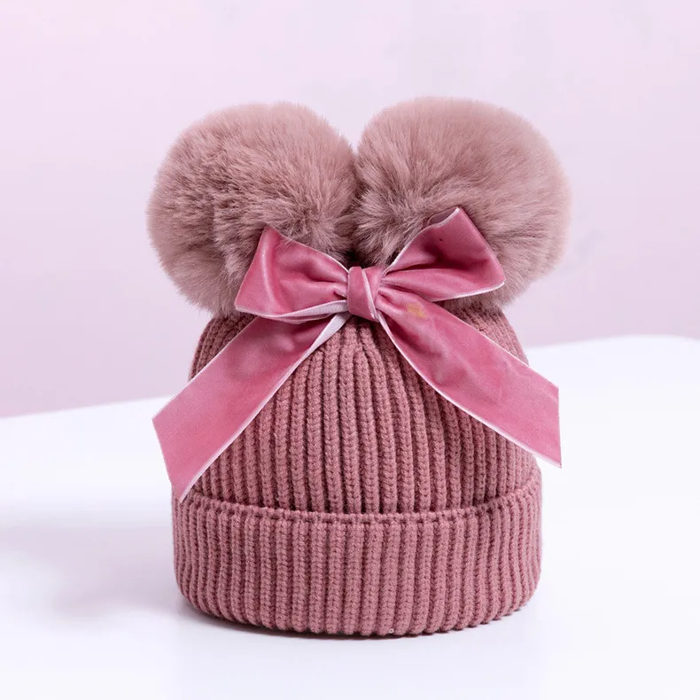 Knitted pompom hat with velvet bow